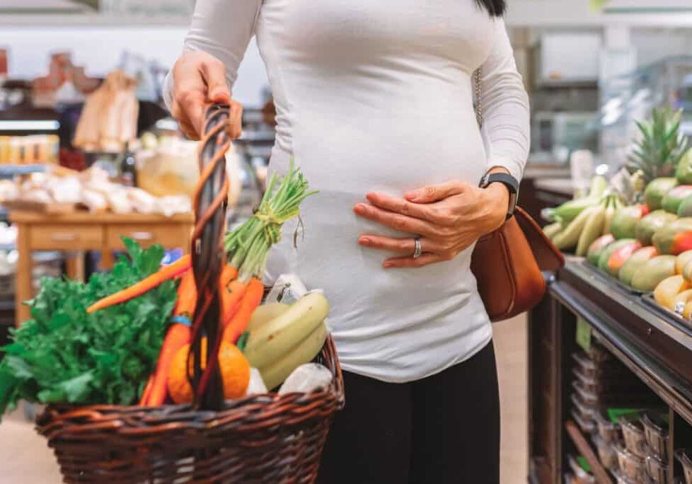 Woman shopping for fresh produce pregnant
